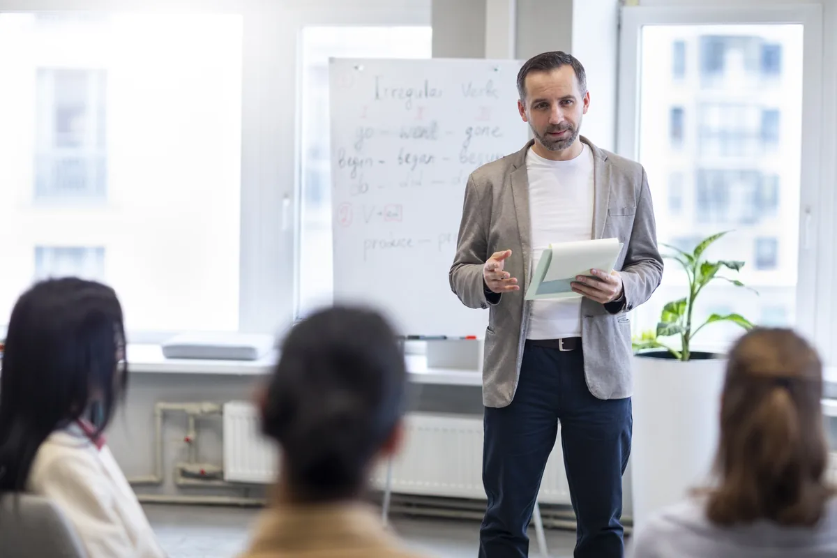 Hombre facilitando una sesión de formación frente a un grupo — liderazgo masculino consciente
